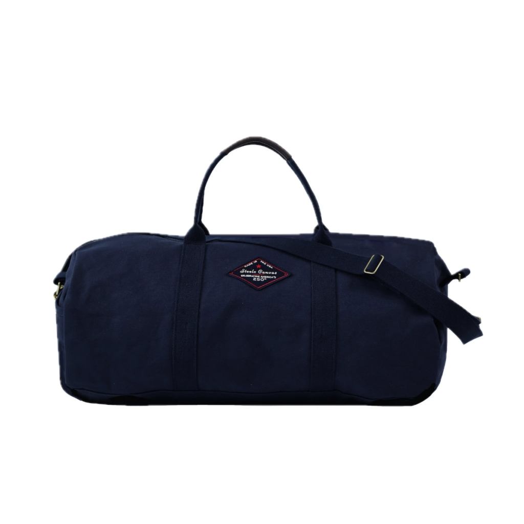 Midnight-navy Steele Canvas duffle bag with handles, shoulder strap, and America’s 250th anniversary patch.