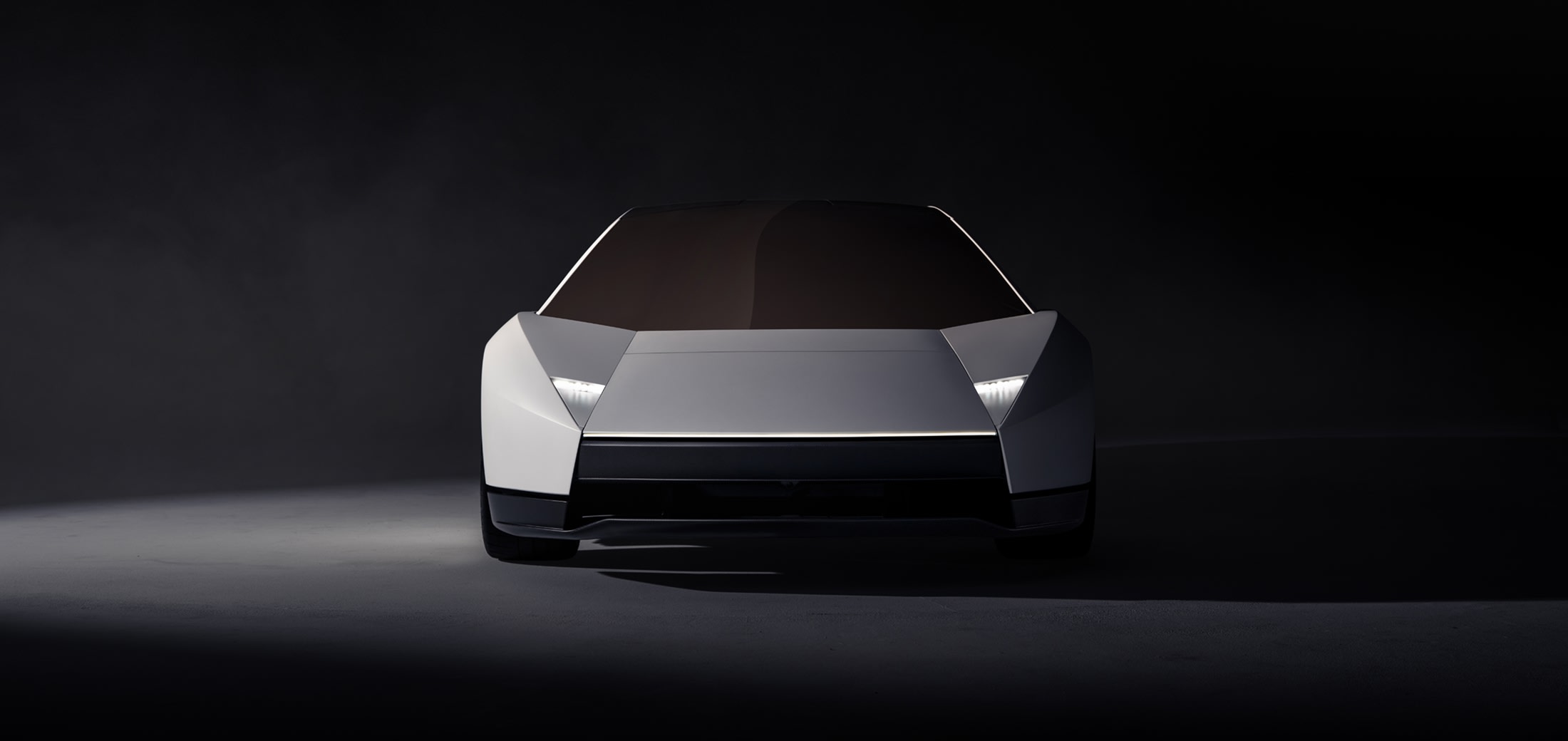 Vue de face de la Tesla Roadster argentée, avec un nez anguleux et des phares étroits.